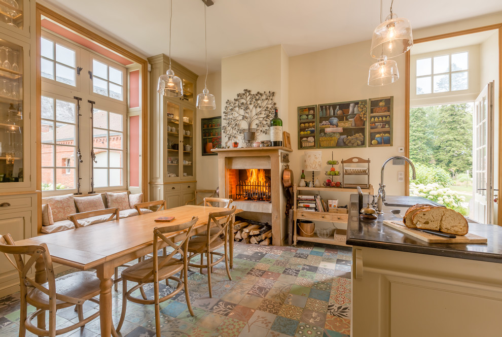 Foto på ett lantligt kök och matrum, med en köksö och flerfärgat golv