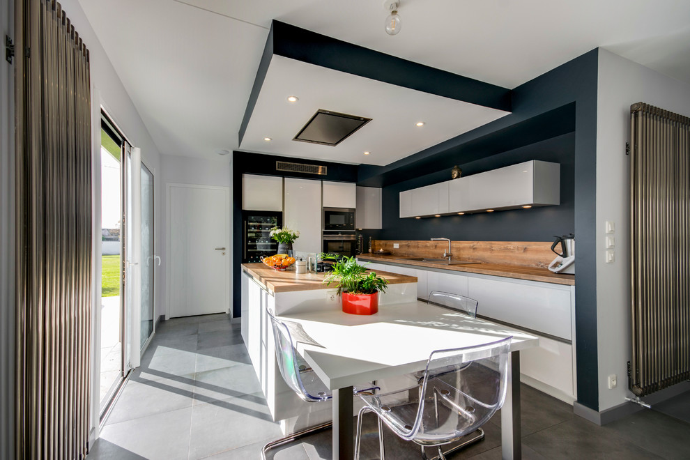 Medium sized contemporary galley kitchen/diner in Toulouse with a single-bowl sink, laminate countertops, stainless steel appliances, an island, grey floors and concrete flooring.