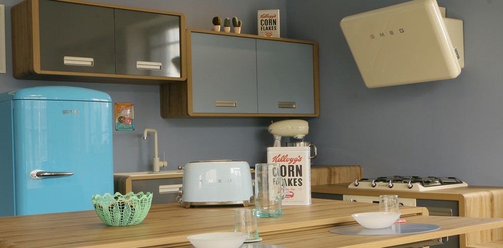 Medium sized retro l-shaped open plan kitchen in Toulouse with a submerged sink, flat-panel cabinets, blue cabinets, laminate countertops, coloured appliances, concrete flooring, an island and grey floors.
