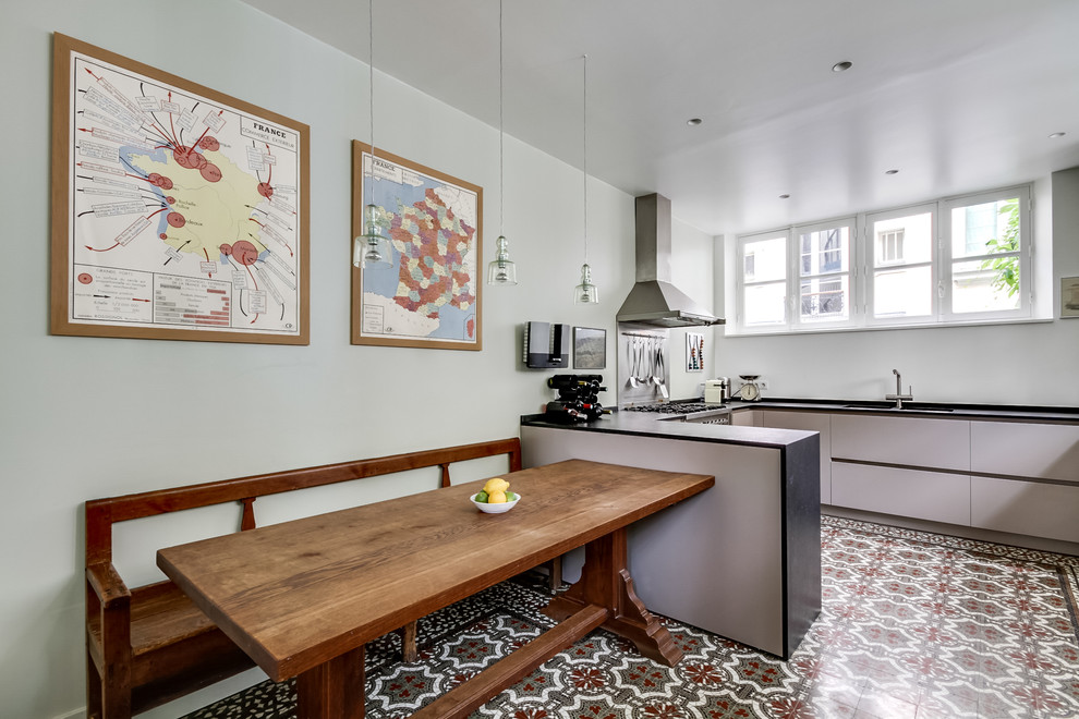 This is an example of a large bohemian u-shaped kitchen/diner in Paris with a submerged sink, granite worktops, stainless steel appliances, ceramic flooring, flat-panel cabinets, grey cabinets, a breakfast bar, metallic splashback and metal splashback.