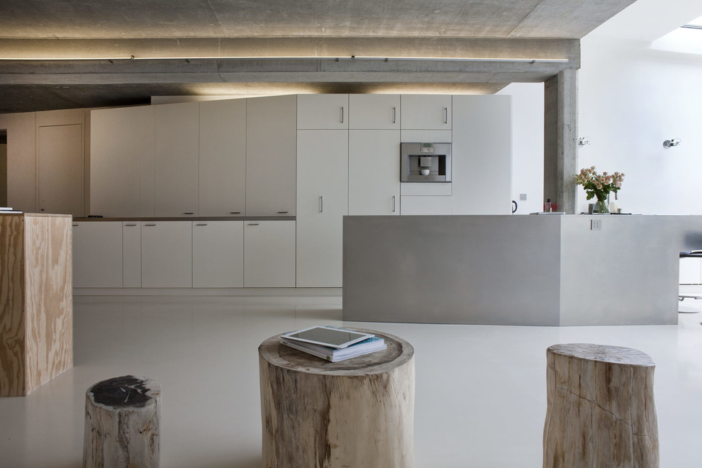 Foto de cocina blanca y madera contemporánea abierta con armarios con paneles empotrados, puertas de armario blancas, salpicadero blanco, electrodomésticos de acero inoxidable, una isla y suelo beige