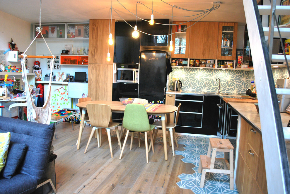 Cette image montre une cuisine ouverte nordique en L et bois clair de taille moyenne avec plan de travail carrelé, une crédence en carreau de ciment et aucun îlot.