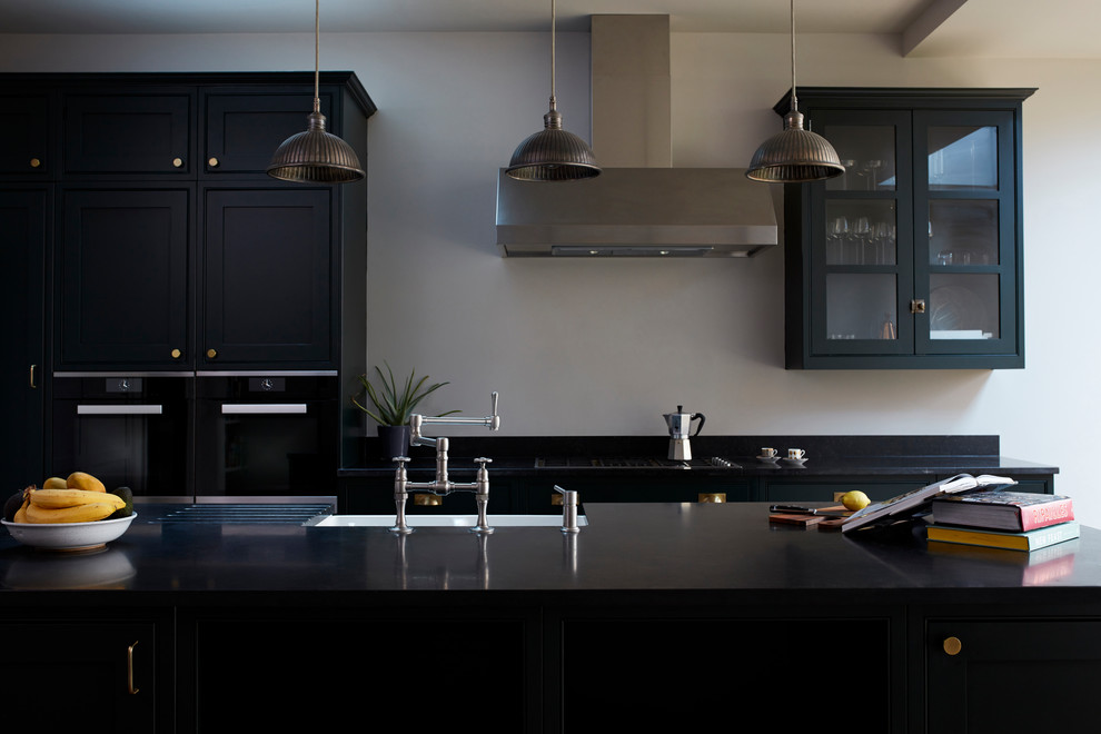 Zweizeilige, Mittelgroße Klassische Küche mit braunem Holzboden, Kücheninsel, beigem Boden und schwarzer Arbeitsplatte in London