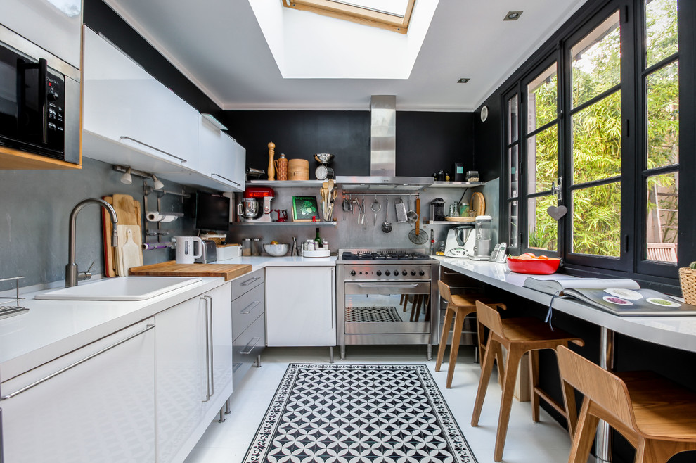 Contemporary u-shaped kitchen in Paris with a built-in sink, flat-panel cabinets, white cabinets, grey splashback, no island, white floors and white worktops.