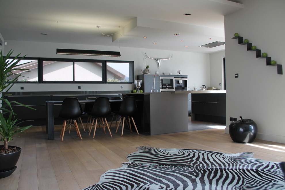 Offene, Zweizeilige, Große Moderne Küche mit hellem Holzboden, grauen Schränken und Kücheninsel in Grenoble