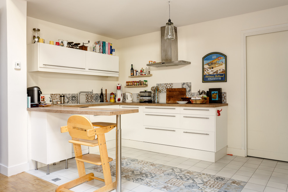 Foto di una cucina ad U bohémian con ante lisce, ante bianche, penisola, pavimento multicolore, top bianco e parquet e piastrelle