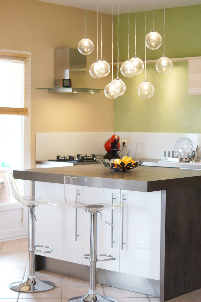 Example of a mid-sized trendy l-shaped eat-in kitchen design in Lyon with white cabinets and an island