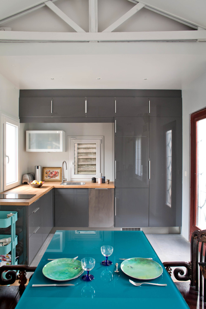 Inspiration for a small contemporary grey and white l-shaped open plan kitchen in Paris with flat-panel cabinets, grey cabinets, wood worktops, a submerged sink, dark hardwood flooring, no island, brown floors, brown worktops and exposed beams.