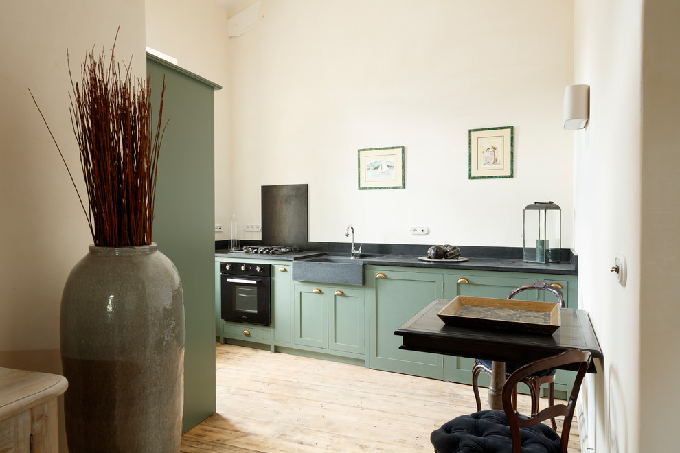 パリにあるお手頃価格の中くらいな地中海スタイルのおしゃれなキッチン (アンダーカウンターシンク、インセット扉のキャビネット、黒いキッチンパネル、ベージュの床、緑のキャビネット、淡色無垢フローリング) の写真