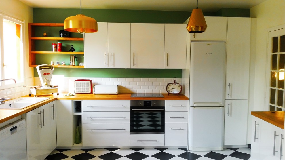 Inspiration för ett avskilt, mellanstort retro l-kök, med en undermonterad diskho, vitt stänkskydd, stänkskydd i tunnelbanekakel, vita skåp, träbänkskiva, vita vitvaror och klinkergolv i keramik