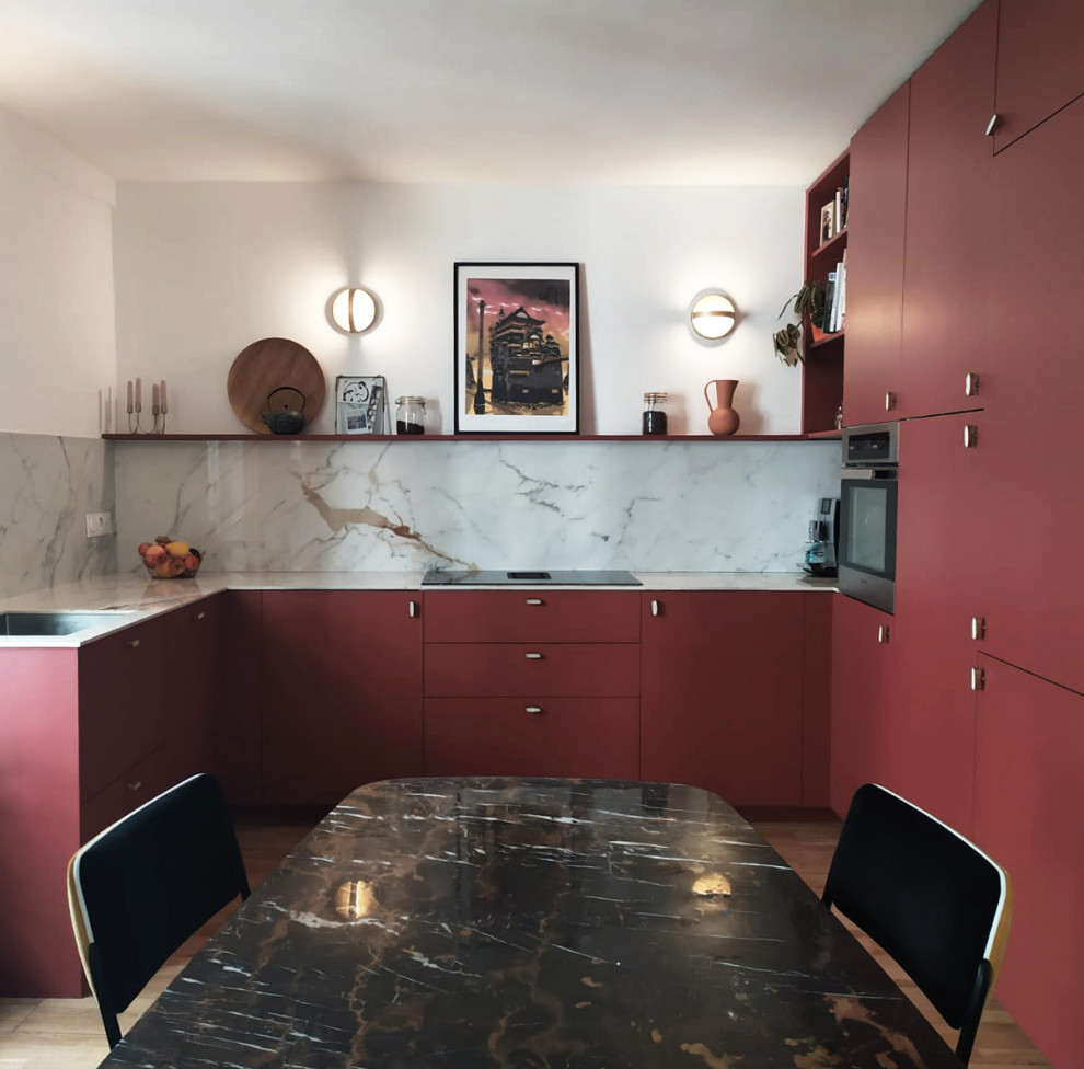 Foto på ett mellanstort funkis grå u-kök, med en undermonterad diskho, släta luckor, röda skåp, grått stänkskydd, integrerade vitvaror och brunt golv