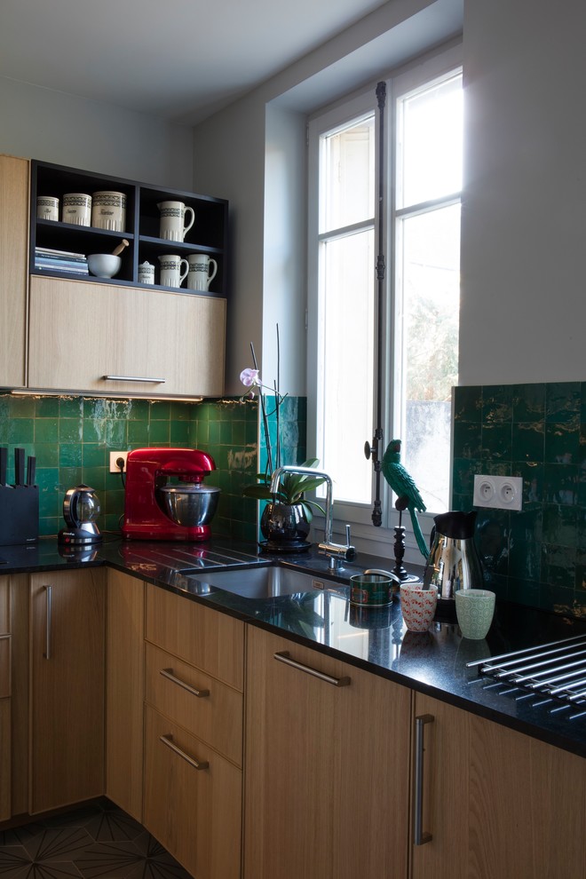 Exempel på ett avskilt, mellanstort eklektiskt u-kök, med en undermonterad diskho, luckor med profilerade fronter, skåp i ljust trä, granitbänkskiva, grönt stänkskydd, stänkskydd i terrakottakakel, rostfria vitvaror, cementgolv och grått golv