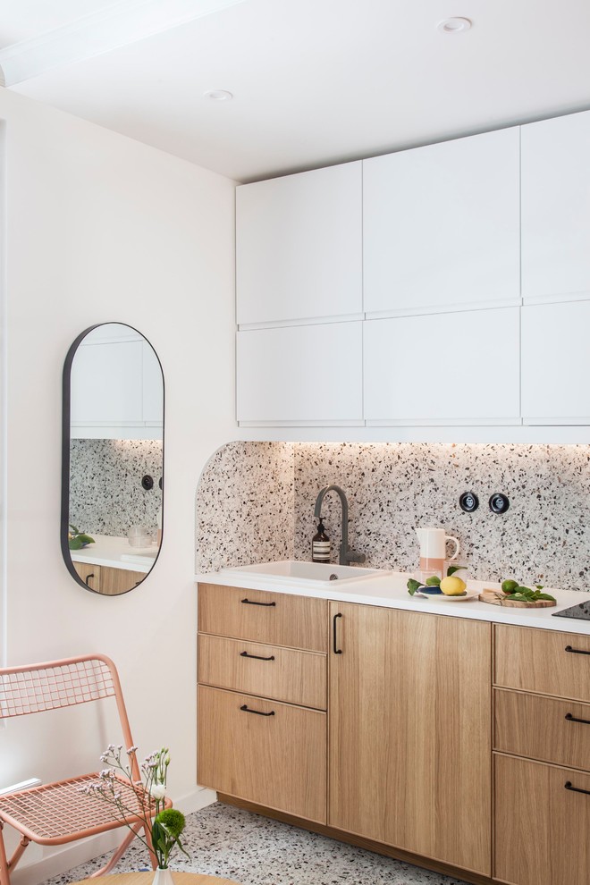 Idéer för ett litet modernt vit linjärt kök med öppen planlösning, med en enkel diskho, luckor med profilerade fronter, skåp i ljust trä, laminatbänkskiva, flerfärgad stänkskydd, stänkskydd i keramik, integrerade vitvaror, terrazzogolv och flerfärgat golv