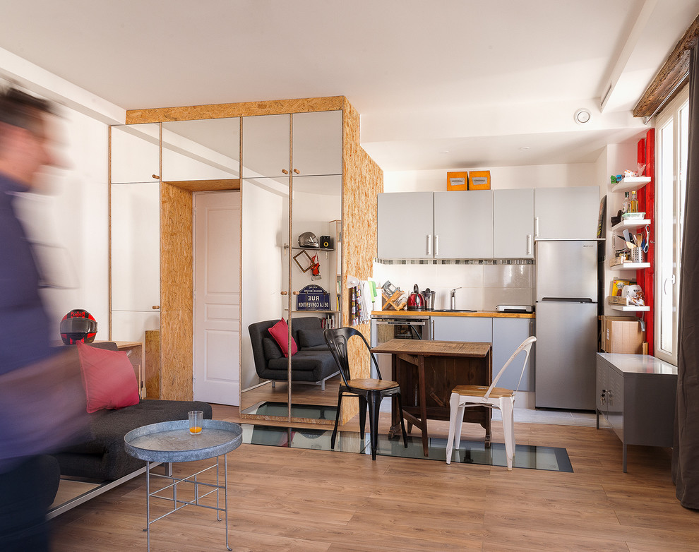 Стильный дизайн: кухня-гостиная в современном стиле с светлым паркетным полом и коричневым полом - последний тренд