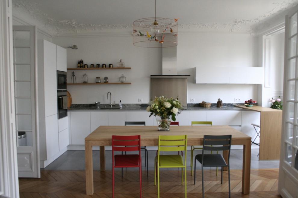 Bild på ett mellanstort funkis kök, med en undermonterad diskho, luckor med profilerade fronter, vita skåp, granitbänkskiva, vitt stänkskydd, integrerade vitvaror, klinkergolv i keramik och grått golv