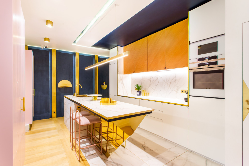Example of a mid-sized trendy single-wall marble floor, white floor and tray ceiling open concept kitchen design in Paris with an integrated sink, beaded inset cabinets, light wood cabinets, marble countertops, white backsplash, marble backsplash, white appliances, an island and white countertops