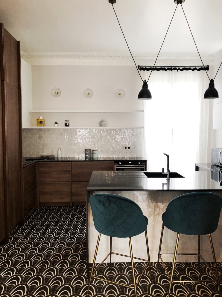 Moderne Küche in L-Form mit Waschbecken, flächenbündigen Schrankfronten, dunklen Holzschränken, Küchenrückwand in Weiß, Rückwand aus Mosaikfliesen, buntem Boden, schwarzer Arbeitsplatte und Halbinsel in Paris