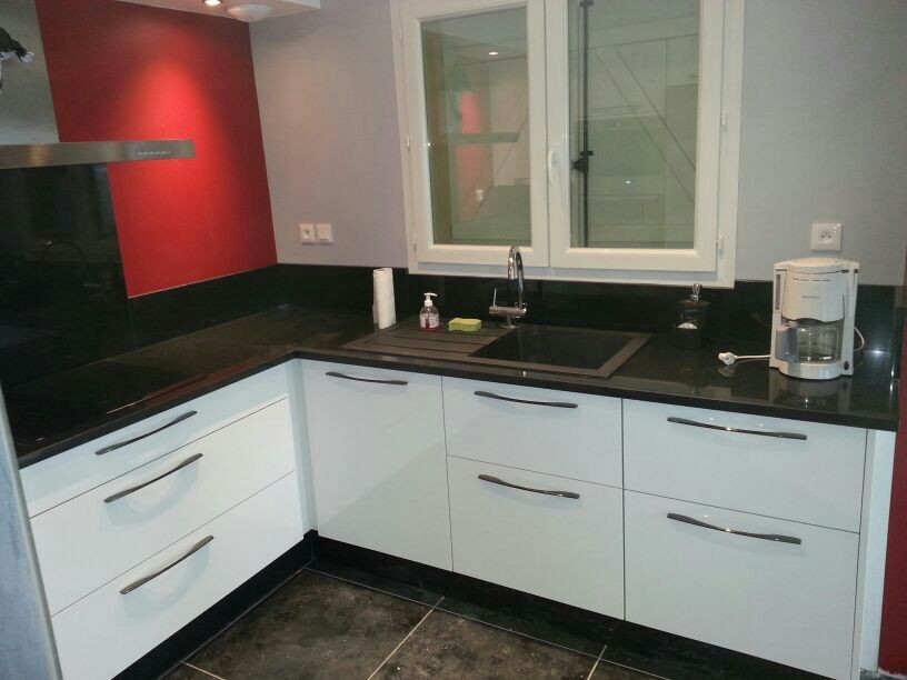Immagine di una piccola cucina contemporanea con lavello a vasca singola, ante lisce, ante bianche, top in granito, paraspruzzi nero e pavimento in cemento