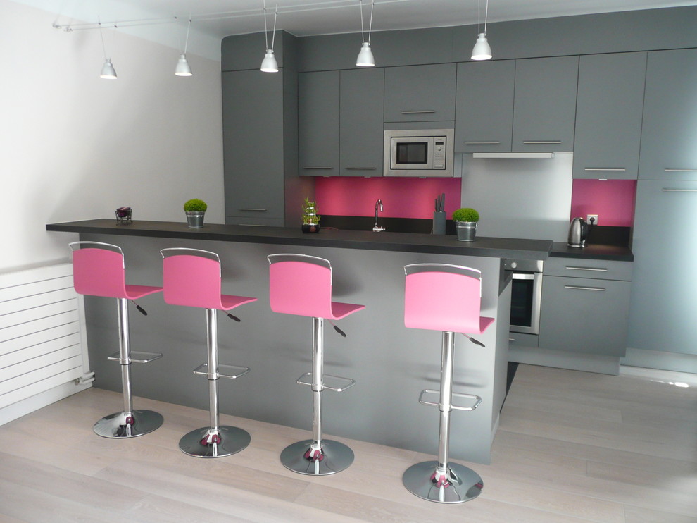 Inspiration för mellanstora moderna kök, med en undermonterad diskho, luckor med profilerade fronter, grå skåp, laminatbänkskiva, rosa stänkskydd, rostfria vitvaror, klinkergolv i keramik, en köksö och svart golv