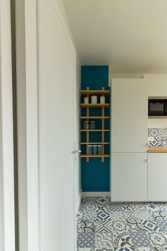 Идея дизайна: отдельная, параллельная кухня среднего размера в скандинавском стиле с белыми фасадами и деревянной столешницей