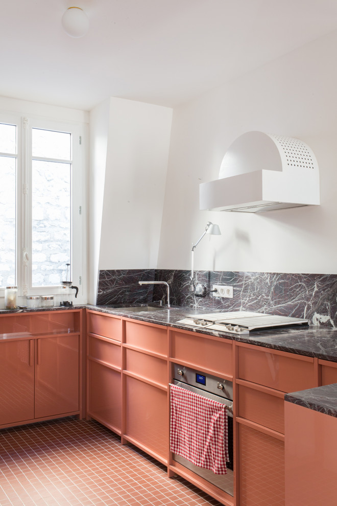 Moderne Küche in U-Form mit Unterbauwaschbecken, orangefarbenen Schränken, bunter Rückwand, Rückwand aus Stein, Küchengeräten aus Edelstahl, orangem Boden und bunter Arbeitsplatte in Paris