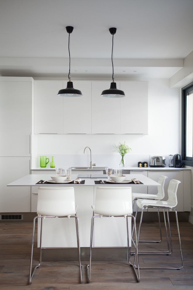 Foto di una cucina design di medie dimensioni con ante lisce, ante bianche e pavimento in legno massello medio