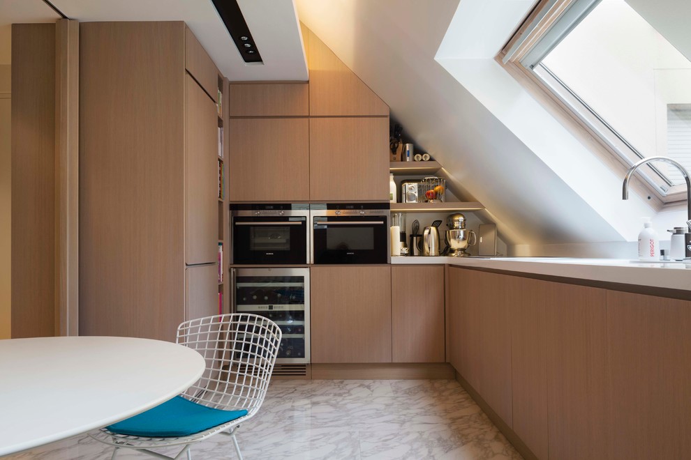 Kleine Skandinavische Wohnküche ohne Insel in U-Form mit flächenbündigen Schrankfronten, hellen Holzschränken, Elektrogeräten mit Frontblende und Marmorboden in Paris