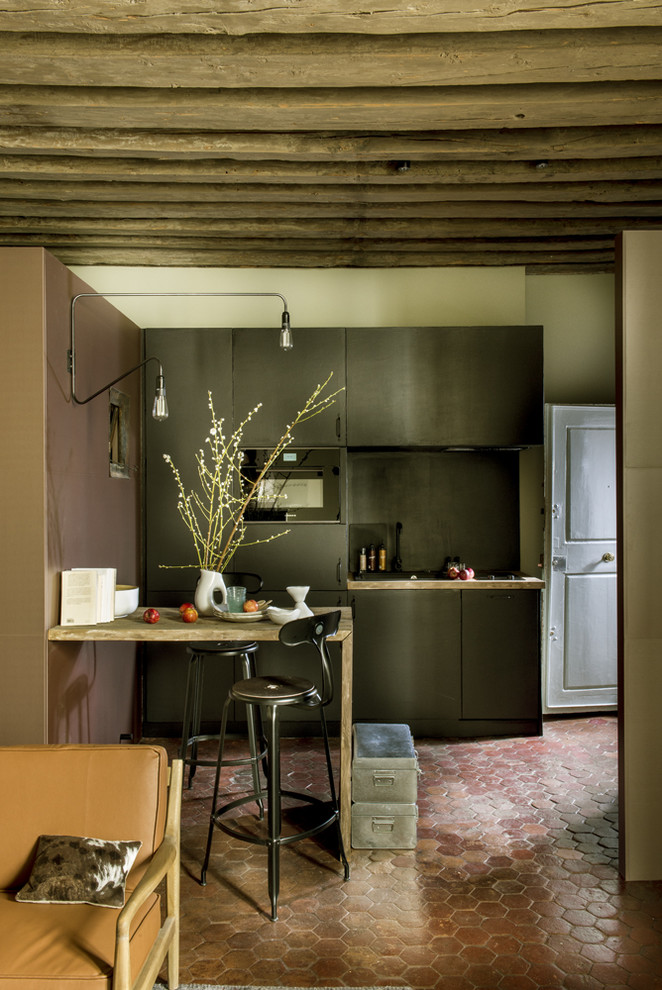 パリにある高級な広いエクレクティックスタイルのおしゃれなキッチン (木材カウンター、シルバーの調理設備、テラコッタタイルの床、アイランドなし、赤い床) の写真