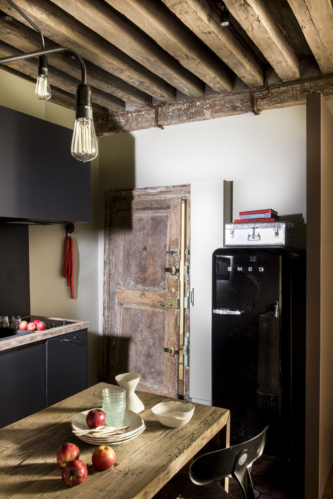 パリにあるお手頃価格の中くらいなエクレクティックスタイルのおしゃれなキッチン (一体型シンク、木材カウンター、シルバーの調理設備、テラコッタタイルの床、赤い床) の写真