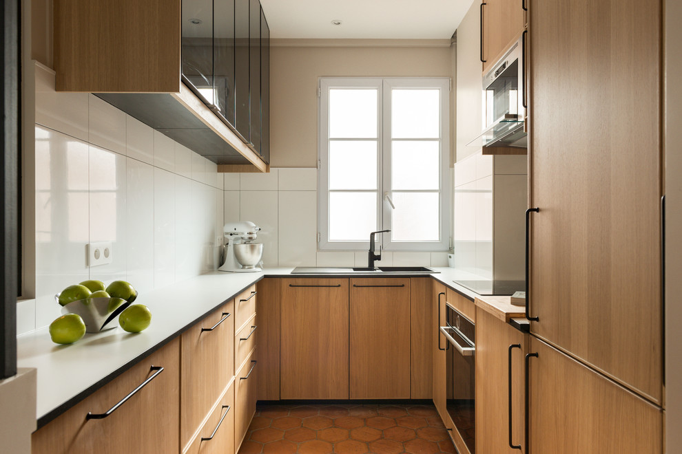 Small classic u-shaped enclosed kitchen in Paris with a submerged sink, medium wood cabinets, laminate countertops, white splashback, ceramic splashback, integrated appliances, terracotta flooring, no island, brown floors, white worktops and flat-panel cabinets.