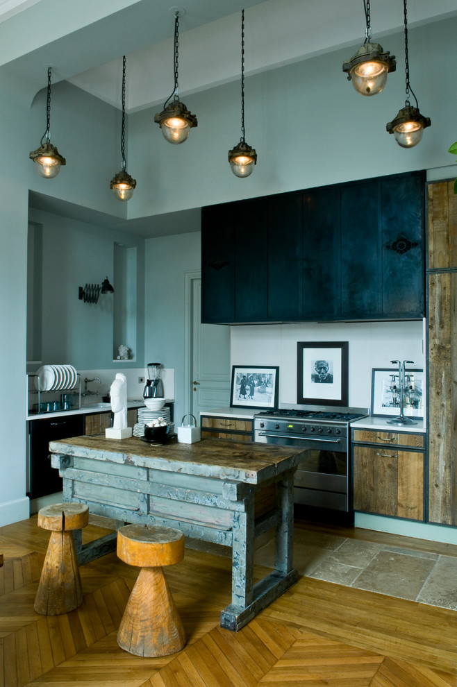 This is an example of a medium sized eclectic l-shaped open plan kitchen in Paris with flat-panel cabinets, medium wood cabinets, white splashback, stainless steel appliances, medium hardwood flooring, an island and beige floors.