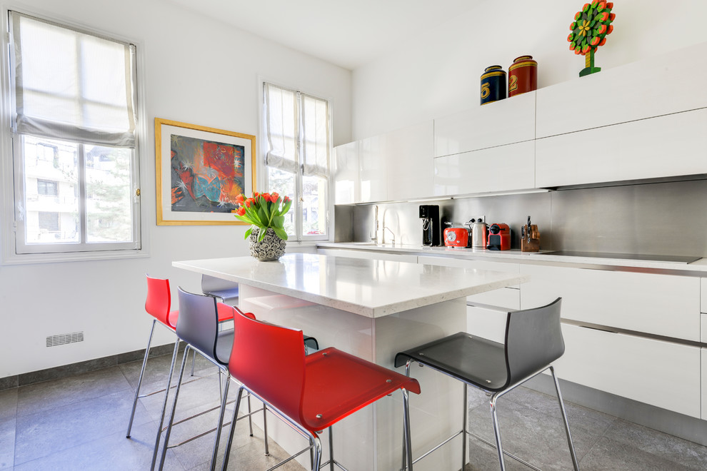 Cette photo montre une grande cuisine tendance avec des portes de placard blanches, un sol en carrelage de céramique, îlot, un sol gris, un placard à porte plane, une crédence métallisée et un plan de travail blanc.