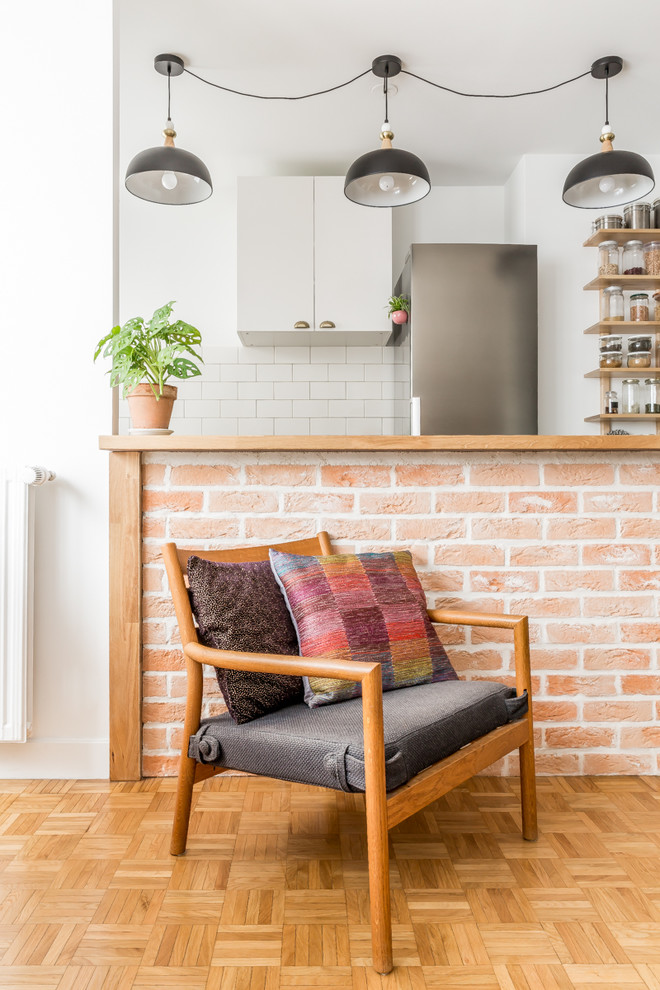 Inspiration pour une cuisine ouverte nordique avec parquet clair, un plan de travail en bois, un électroménager en acier inoxydable et un sol marron.