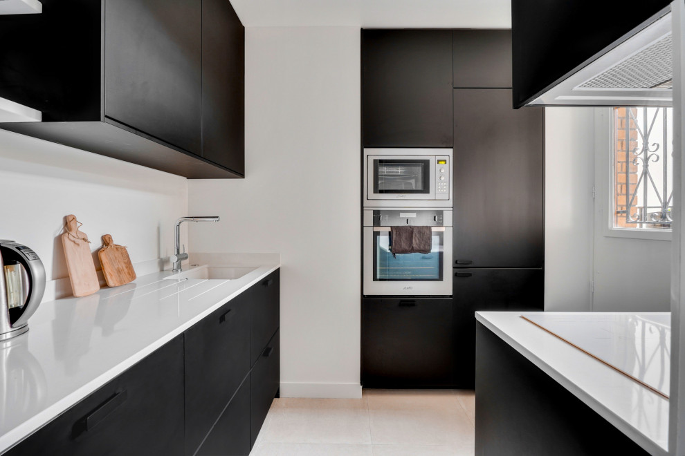 Ispirazione per una cucina design con lavello sottopiano, ante lisce, ante nere, elettrodomestici in acciaio inossidabile, pavimento beige e top bianco