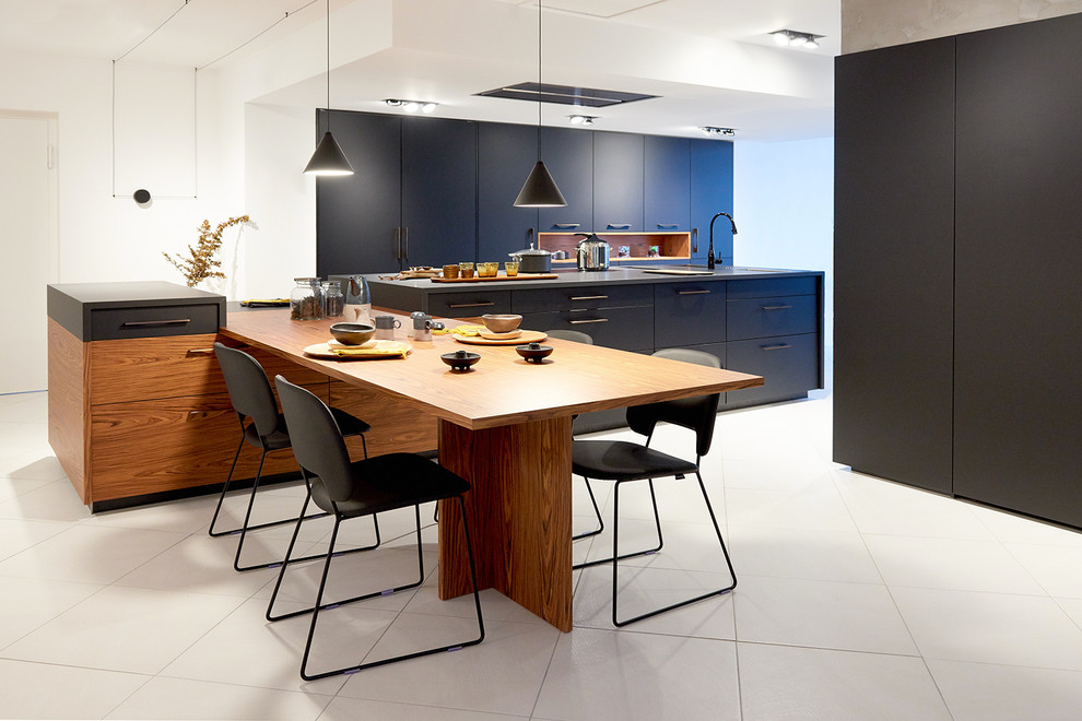 Zweizeilige, Große Moderne Wohnküche mit blauen Schränken, Elektrogeräten mit Frontblende und Kücheninsel in Lyon