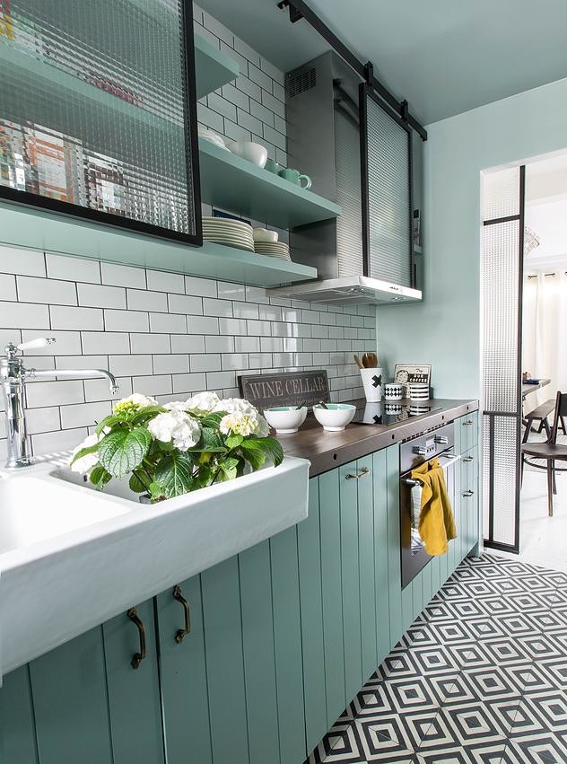 パリにあるお手頃価格の中くらいなミッドセンチュリースタイルのおしゃれなキッチン (ダブルシンク、木材カウンター、白いキッチンパネル、サブウェイタイルのキッチンパネル、パネルと同色の調理設備、セラミックタイルの床、緑のキャビネット、アイランドなし、フラットパネル扉のキャビネット) の写真