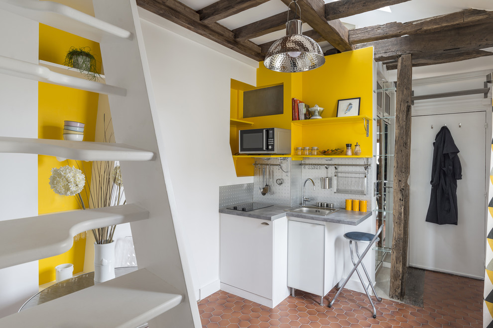 Bild på ett litet funkis linjärt kök och matrum, med en undermonterad diskho, laminatbänkskiva, stänkskydd i metallkakel, rostfria vitvaror och klinkergolv i terrakotta