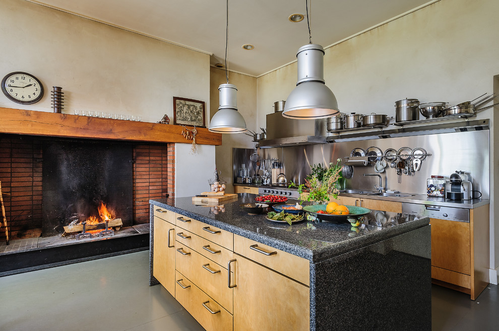 Exemple d'une cuisine ouverte parallèle industrielle en bois clair de taille moyenne avec un évier 2 bacs, un placard à porte plane, une crédence métallisée, un électroménager en acier inoxydable, îlot et un plan de travail en inox.