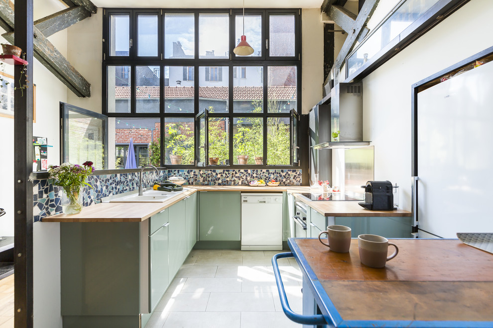 Urban u-shaped kitchen in Other with a double-bowl sink, flat-panel cabinets, green cabinets, wood worktops, multi-coloured splashback, white appliances, white floors and beige worktops.