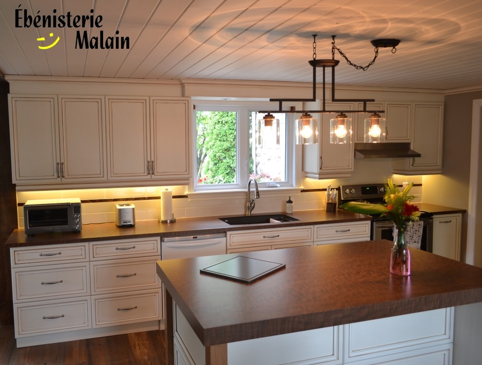 Bild på ett stort lantligt linjärt kök med öppen planlösning, med en undermonterad diskho, luckor med infälld panel, skåp i slitet trä, laminatbänkskiva, vitt stänkskydd, stänkskydd i keramik, rostfria vitvaror, mörkt trägolv och en köksö