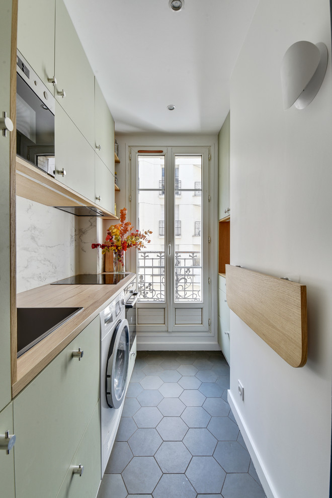 Inspiration for a contemporary single-wall enclosed kitchen in Paris with a built-in sink, flat-panel cabinets, green cabinets, wood worktops, white splashback, integrated appliances, cement flooring, no island, grey floors and beige worktops.