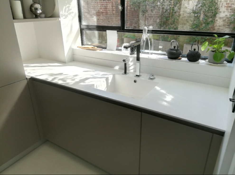 Foto di una piccola cucina lineare minimal chiusa con lavello integrato, top in superficie solida, paraspruzzi bianco, nessuna isola e top bianco