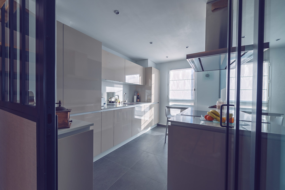 Inspiration for a small contemporary galley enclosed kitchen in Rennes with an integrated sink, beaded cabinets, beige cabinets, quartz worktops, white splashback, stainless steel appliances, ceramic flooring and grey floors.