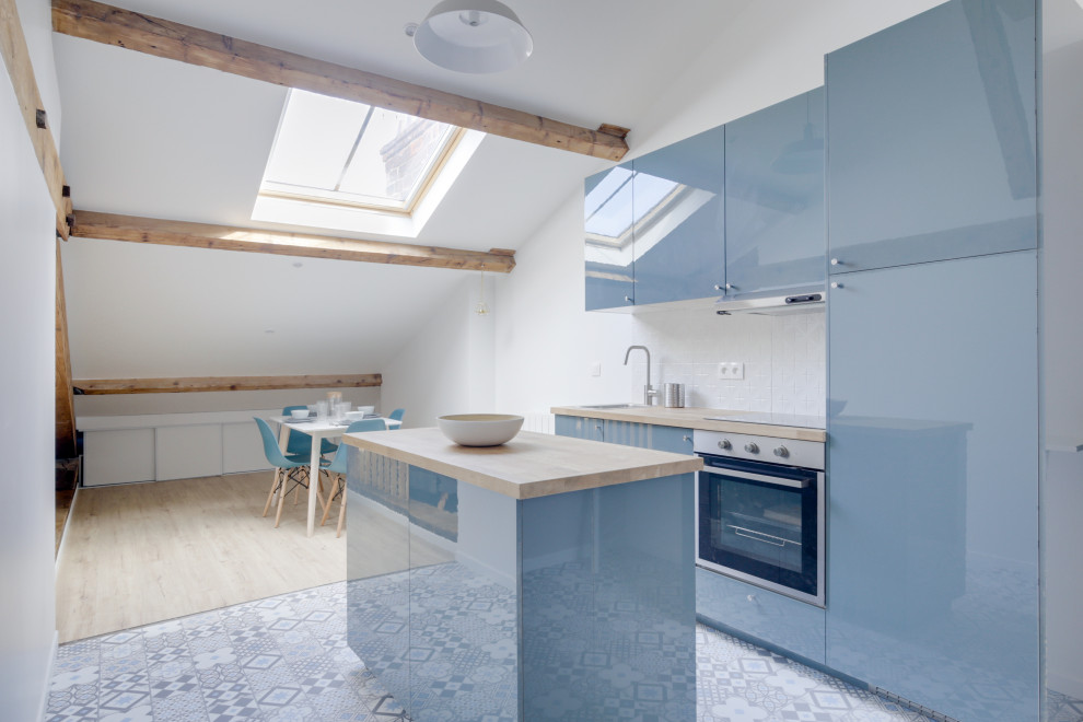 Inspiration for a small scandi galley open plan kitchen in Marseille with a submerged sink, blue cabinets, wood worktops, ceramic splashback, integrated appliances, cement flooring, an island, grey floors and exposed beams.