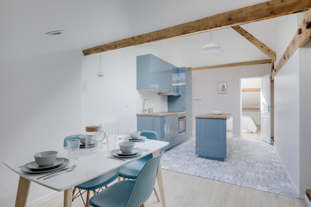 Idee per una piccola cucina scandinava con lavello sottopiano, ante blu, top in legno, paraspruzzi con piastrelle in ceramica, elettrodomestici da incasso, pavimento in cementine, pavimento grigio e travi a vista