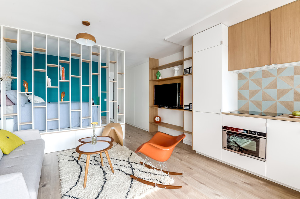 Cette photo montre une petite cuisine ouverte encastrable et linéaire scandinave avec un plan de travail en bois, une crédence bleue, aucun îlot, des portes de placard blanches et parquet clair.