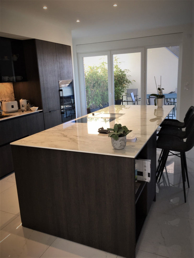 Inspiration for a large contemporary galley open plan kitchen in Rennes with beaded cabinets, dark wood cabinets, white splashback, ceramic flooring, an island, white floors and white worktops.