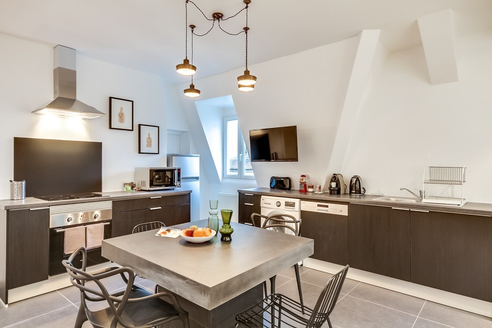 Ejemplo de cocina contemporánea, grande, con fregadero de un seno, puertas de armario negras, salpicadero negro, electrodomésticos con paneles, suelo de baldosas de cerámica y una isla