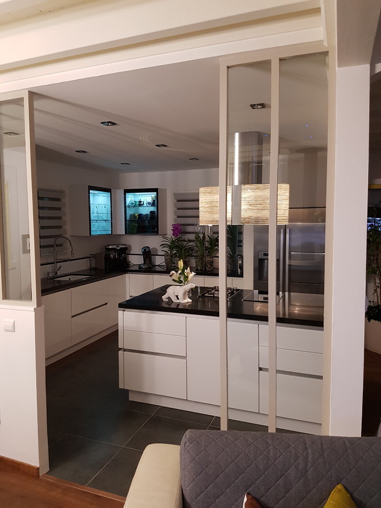 This is an example of a medium sized modern u-shaped open plan kitchen in Other with a single-bowl sink, beaded cabinets, white cabinets, white splashback, stainless steel appliances, ceramic flooring and an island.