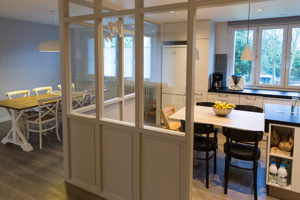 Modelo de cocina comedor lineal contemporánea de tamaño medio con puertas de armario blancas y suelo de madera en tonos medios